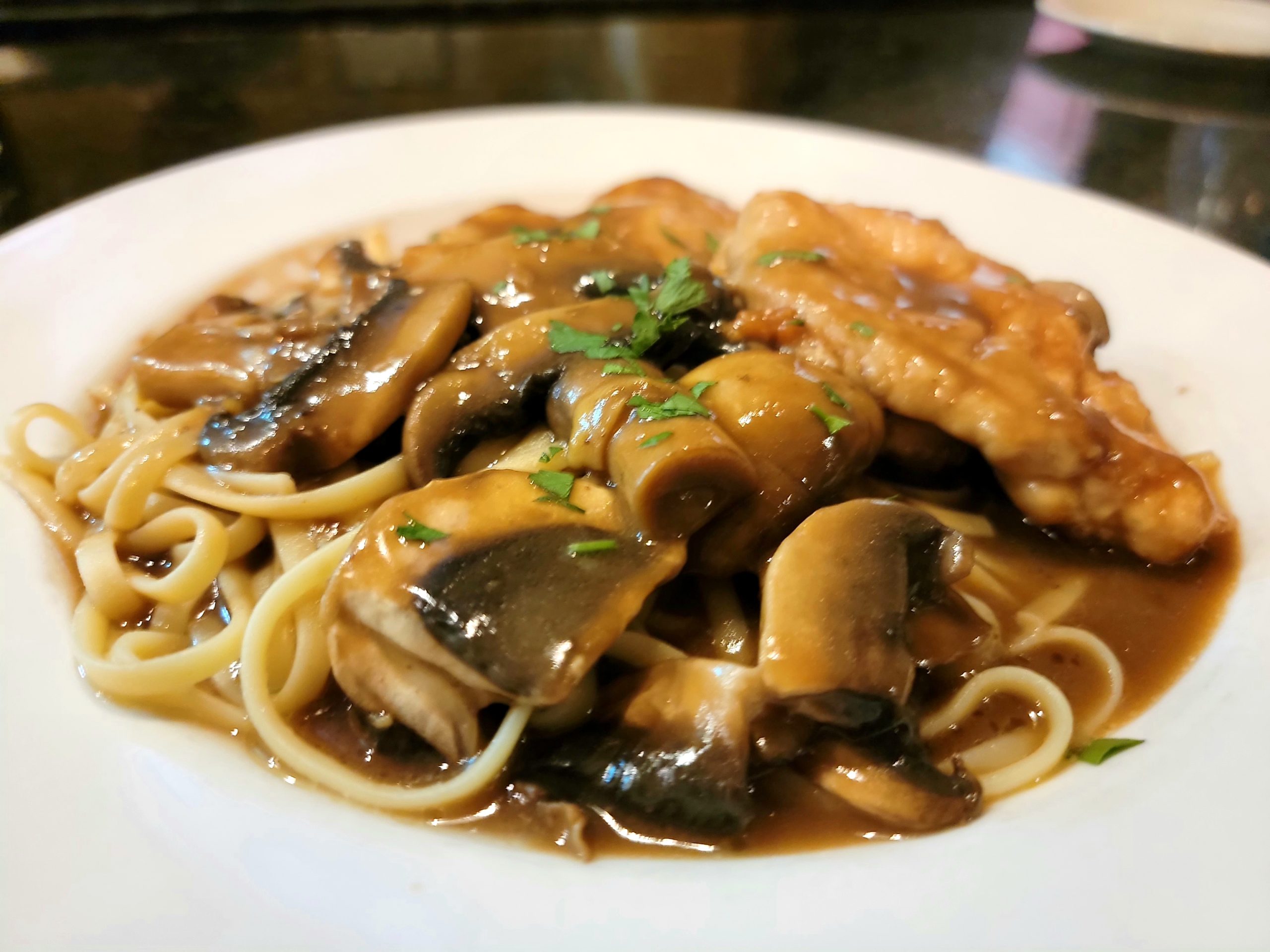 Chicken marsala with mushrooms over linguine